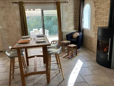 a living room with a table and chairs and a fireplace at Gîte avec jacuzzi, et accès privé à la rivière in Ladern-sur-Lauquet