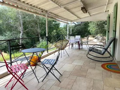a patio with chairs and a table on a balcony at Gîte avec jacuzzi, et accès privé à la rivière in Ladern-sur-Lauquet