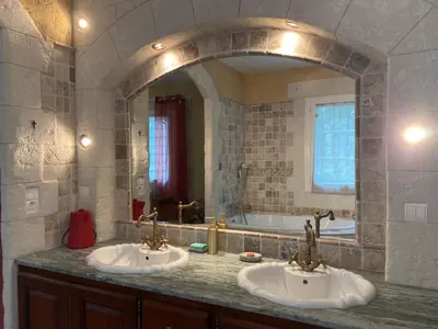 a bathroom with two sinks and a large mirror at Gîte avec jacuzzi, et accès privé à la rivière in Ladern-sur-Lauquet