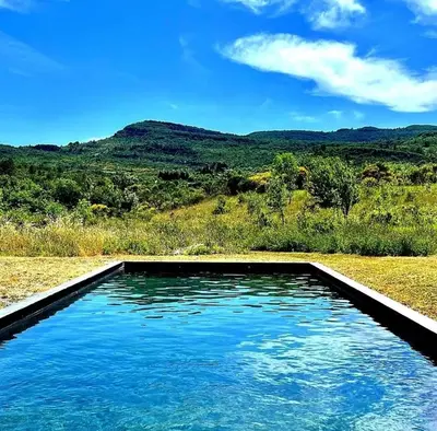 a swimming pool with blue water in a field at Piano apartment in Taurize