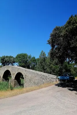 a stone bridge with a car parked on the side of a road at Piano apartment in Taurize
