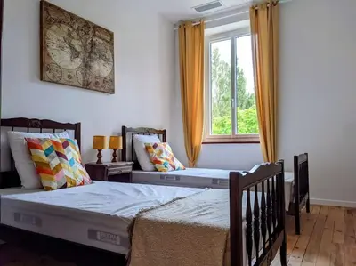two beds in a bedroom with a window at Gîte à la ferme in Floure