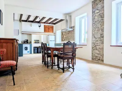 a kitchen and dining room with a table and chairs at Gîte à la ferme in Floure