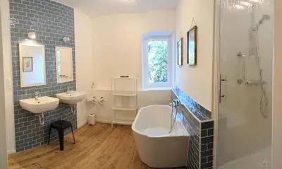 a bedroom with a shower and a bed and a sink at Gîte à la ferme in Floure