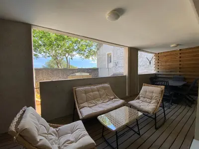 a screened in porch with two chairs and a table at T3 bis bord du canal du midi piscine in Homps