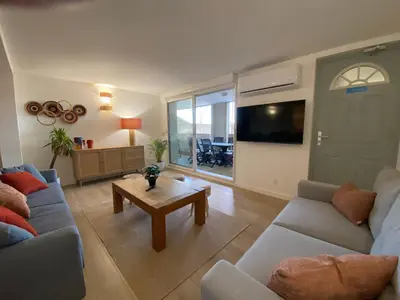 a living room with a couch and a table at T3 bis bord du canal du midi piscine in Homps