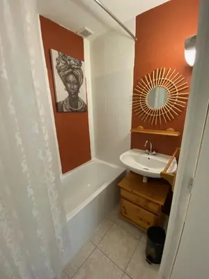 a bathroom with a sink and a tub and a mirror at Os-thel, Chambres à louer in Tautavel
