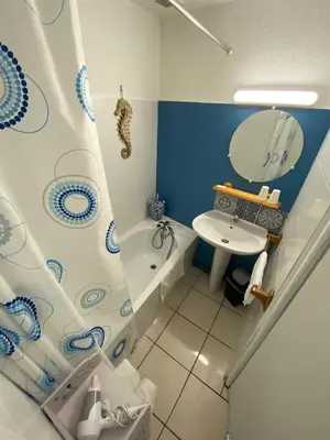 a bathroom with a shower curtain and a sink at Os-thel, Chambres à louer in Tautavel