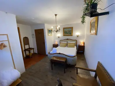 a bedroom with a bed and a couch in a room at Os-thel, Chambres à louer in Tautavel