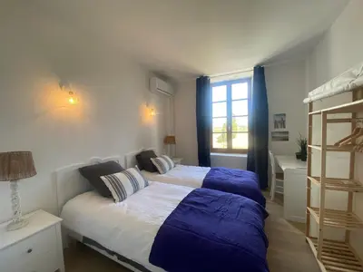 a bedroom with a bed with blue and white sheets at Maison, canal du midi piscine in Homps