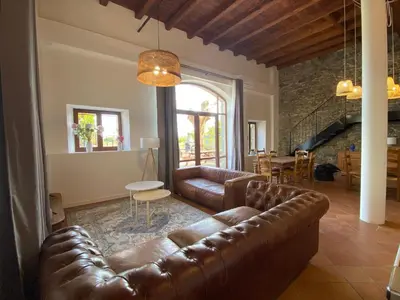 a living room with a leather couch and a table at Maison, canal du midi piscine in Homps