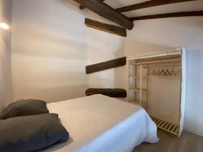 a bedroom with a white bed and a closet at Maison, canal du midi piscine in Homps