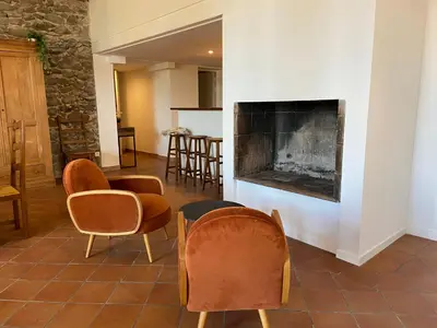 a living room with chairs and a fireplace at Maison, canal du midi piscine in Homps
