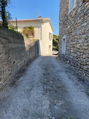 an empty road in front of a stone building at La P’tite Maison de David in Saint-Hilaire