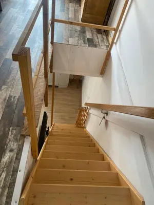 a set of stairs in a house with wooden floors at La P’tite Maison de David in Saint-Hilaire