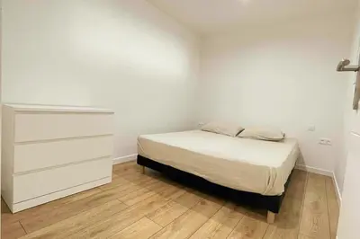a white bedroom with a bed and a dresser at Cozy & Elegant Appartement Narbonne in Narbonne