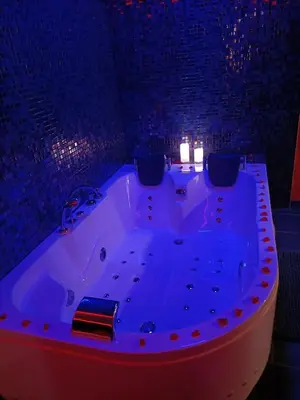 a large bath tub in a room with lights at L'instant romance Le Romantique in Castelnaudary