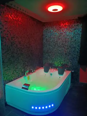 a bath tub in a room with red lights at L'instant romance Le Romantique in Castelnaudary