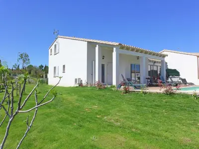 a white house with a yard and a pool at Serene Villa Stay near Narbonne in Narbonne