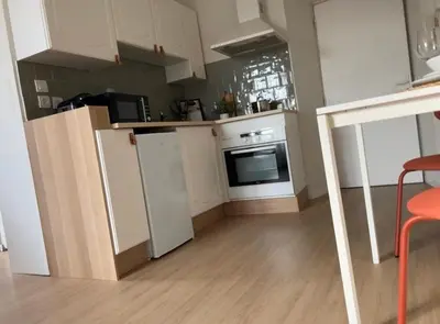 a kitchen with white appliances and a wooden floor at Studio hyper centre de castres in Castres