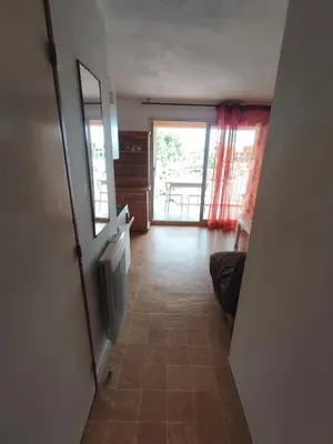 a hallway with a door leading to a living room at APPARTEMENT DE VACANCES A LA MER DANS RESIDENCE SECURISEE in Gruissan