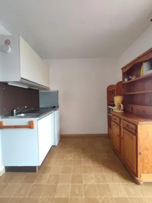 a kitchen with white appliances and wooden cabinets at APPARTEMENT DE VACANCES A LA MER DANS RESIDENCE SECURISEE in Gruissan