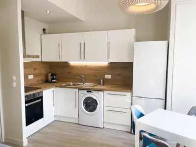 a kitchen with white cabinets and a washing machine at Le Baya - Appt proche des Halles in Narbonne