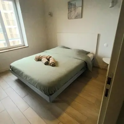 a bed in a small room with a window at Le Baya - Appt proche des Halles in Narbonne
