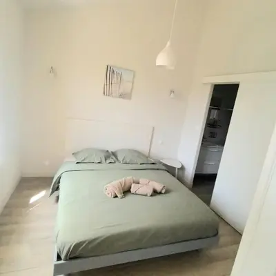 a bedroom with a bed with a stuffed animal on it at Le Baya - Appt proche des Halles in Narbonne
