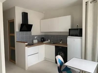 a kitchen with white cabinets and a white refrigerator at Le Woltu - Appt proche des Halles in Narbonne