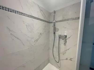 a bathroom with a shower with white marble at Le Woltu - Appt proche des Halles in Narbonne