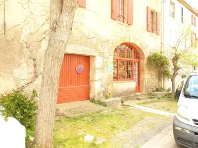 a house with a red door and a car parked in front at GîTE-FAMILLE NOMBREUSE-SÉMINAIRE-PATIO in Ornaisons