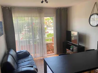 a living room with a chair and a table and a window at Beau T3 - plain pied - terrasses in Port-la-Nouvelle