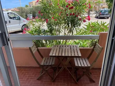 a wooden table and two chairs on a balcony at Beau T3 - plain pied - terrasses in Port-la-Nouvelle