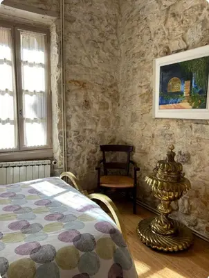 a bedroom with a bed and a painting on the wall at Chez Elise - Gîte de charme - Abbaye de Fontfroide in Bizanet