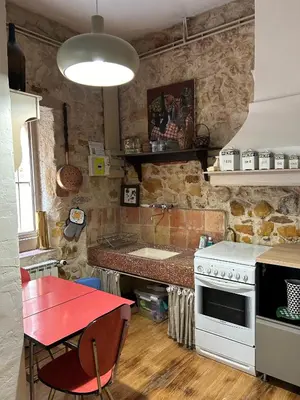 a kitchen with a white stove and a red table at Chez Elise - Gîte de charme - Abbaye de Fontfroide in Bizanet