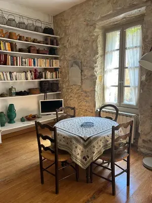 a dining room with a table and chairs and a book shelf at Chez Elise - Gîte de charme - Abbaye de Fontfroide in Bizanet