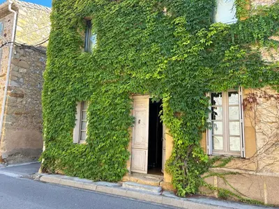 a building covered in ivy with a door and windows at Chez Elise - Gîte de charme - Abbaye de Fontfroide in Bizanet