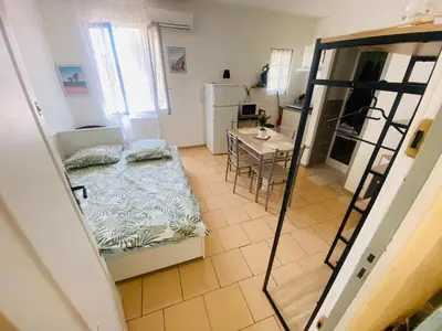 a small room with a bed and a kitchen at Le studio du Port in Port-la-Nouvelle