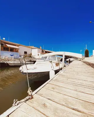 a boat docked next to a dock with a boat sidx sidx at Le studio du Port in Port-la-Nouvelle