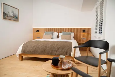 a bedroom with a bed and a chair and a table at Bouquerie Lagrasse in Lagrasse