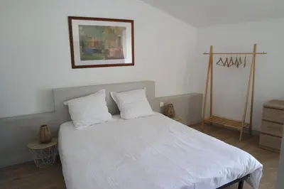 a bedroom with a white bed with two pillows at Loft Porte Sud 140 m2 in Salles-d'Aude
