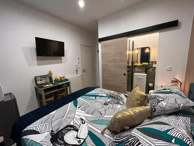 a bedroom with a bed and a television on the wall at LA MADDYSON in Narbonne