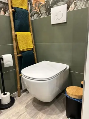 a bathroom with a toilet and towels on a shelf at LA MADDYSON in Narbonne