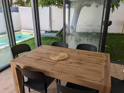 a wooden table with chairs around it with a hat on it at Petite Bulle in Narbonne