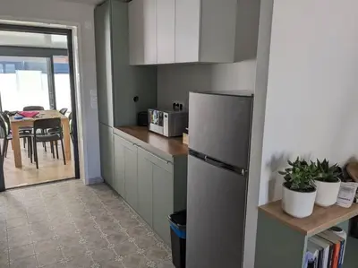 a kitchen with a stainless steel refrigerator and a table at Petite Bulle in Narbonne