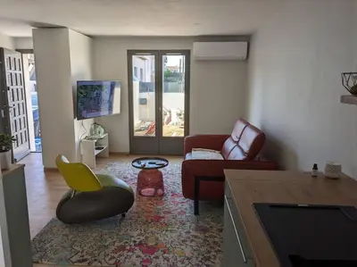 a living room with a couch and a chair at Petite Bulle in Narbonne