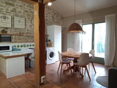 a kitchen and dining room with a table and chairs at Au Repos in Tréziers