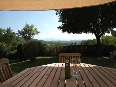 a bottle of wine and two glasses on a wooden table at Au Repos in Tréziers