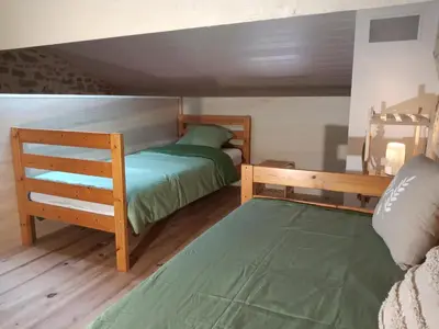 a bedroom with two bunk beds and a green bed at Au Repos in Tréziers